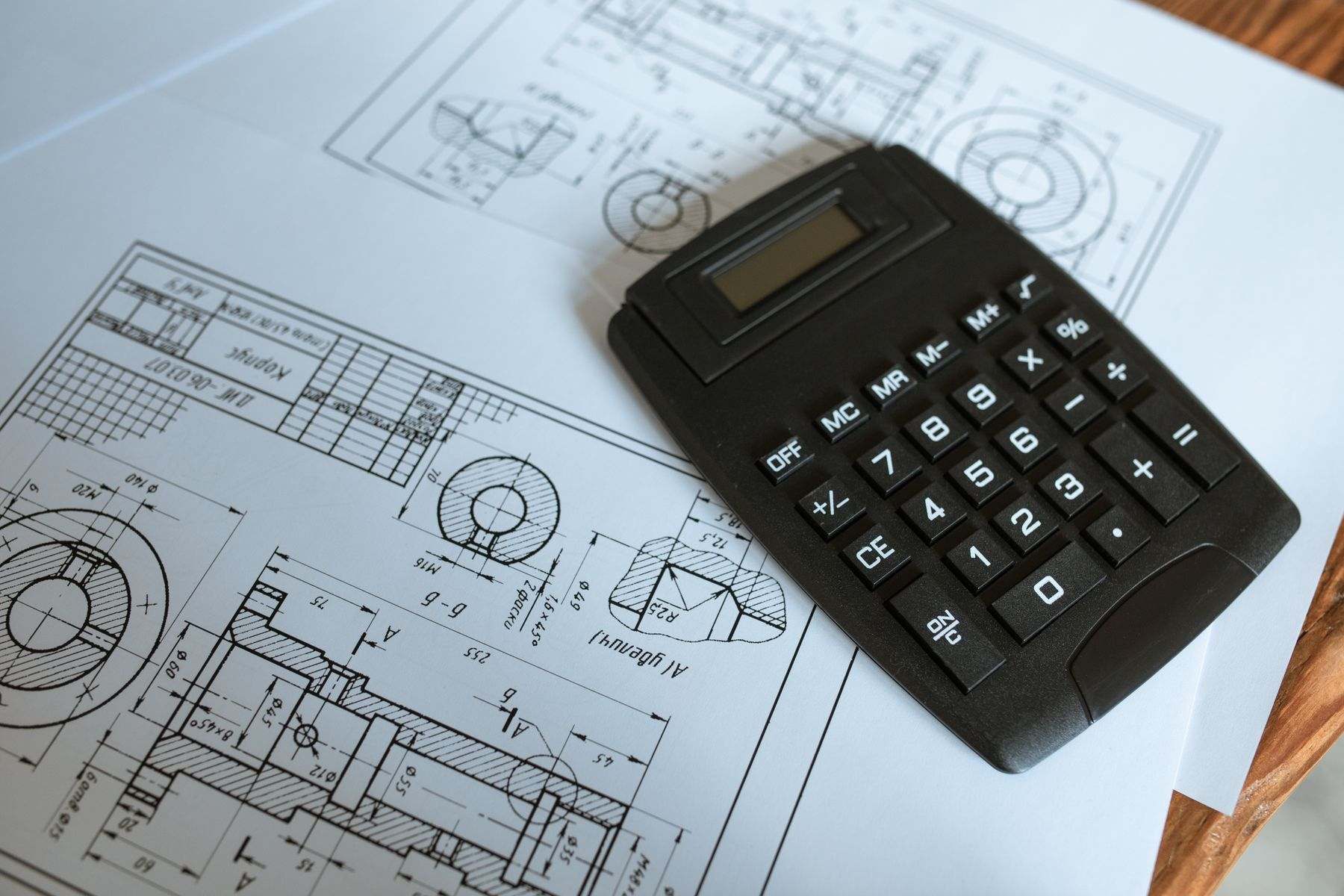Máy tính bỏ túi đặt trên bản vẽ kỹ thuật